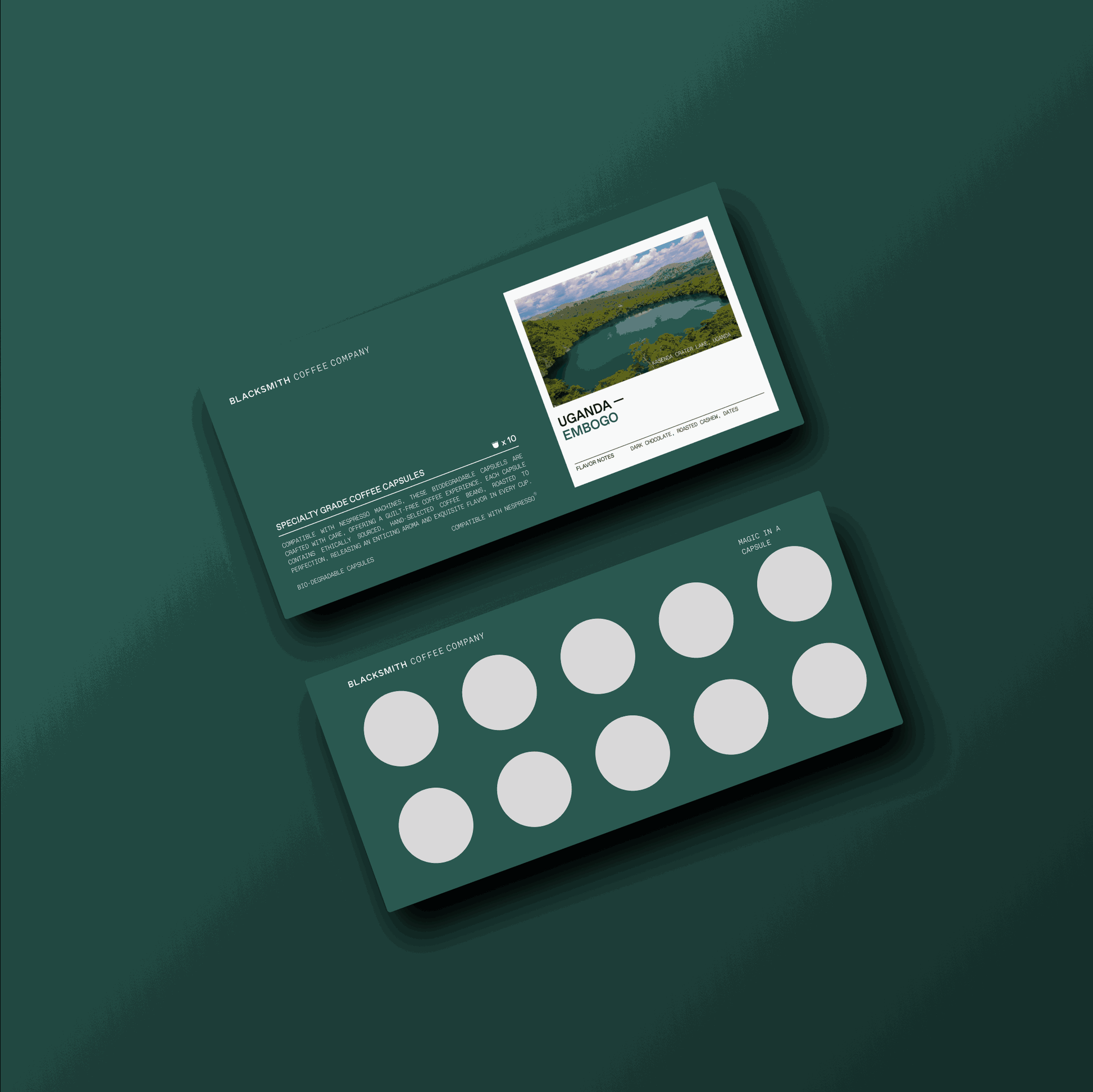 Dark green packaging of Uganda Embogo coffee capsules with a scenic landscape photo and text on the box